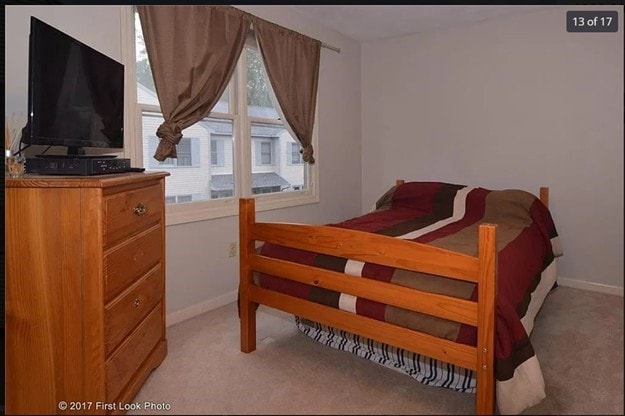 bedroom with light colored carpet and baseboards