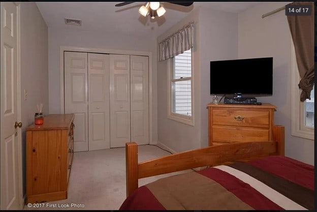 bedroom with a ceiling fan, a closet, visible vents, and light colored carpet