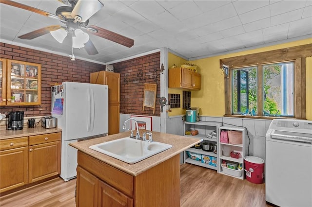 48 Highview Ave, Hopkinton, RI 02832 - kitchen featuring washer / clothes dryer, freestanding refrigerator, a sink, light wood-style floors, and brick wall