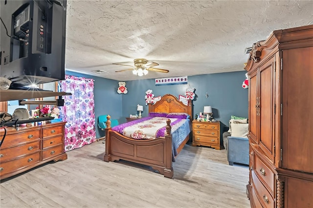 bedroom with a ceiling fan, light wood finished floors, and a textured ceiling