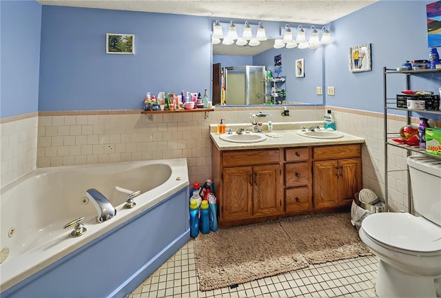 full bath featuring a sink, tile walls, toilet, a wainscoted wall, and a tub with jets