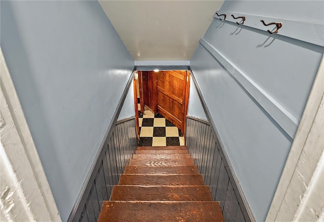 staircase featuring wood walls