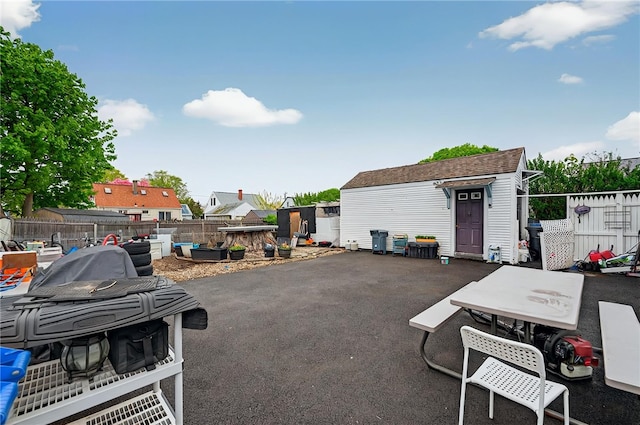 view of patio with an outbuilding, outdoor dining space, and a fenced backyard