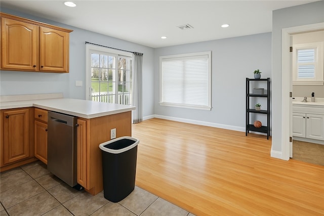 17 Grotto Ave Unit 1, Pawtucket, RI 02860 - kitchen featuring a peninsula, stainless steel dishwasher, visible vents, light countertops, and light wood-style floors