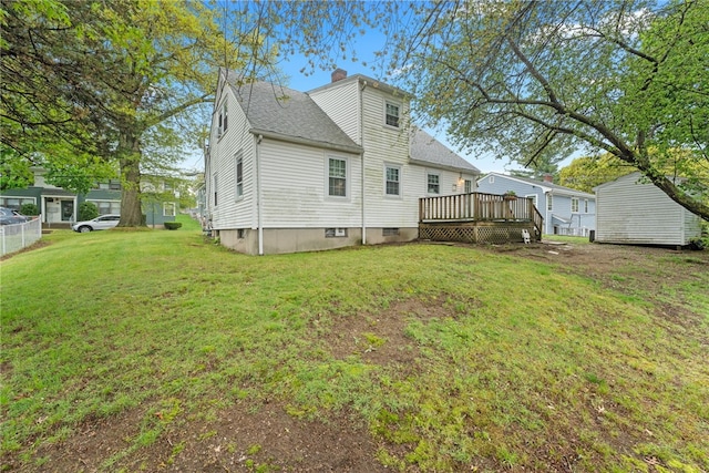 141 Burns St, Providence, RI 02904 - back of property featuring a yard, a wooden deck, a shingled roof, and a chimney