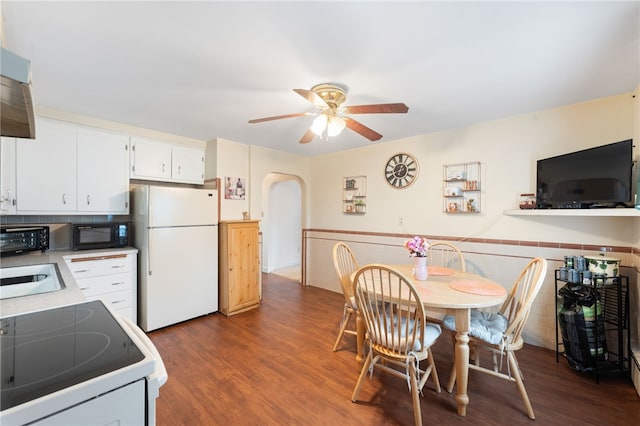 141 Burns St, Providence, RI 02904 - dining room featuring arched walkways, ceiling fan, a wainscoted wall, and dark wood-type flooring