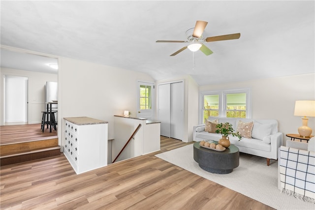living room with light wood-style floors, lofted ceiling, and ceiling fan