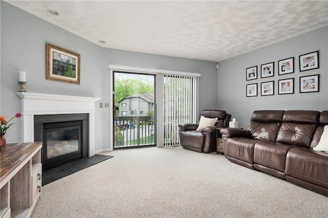 living area with carpet flooring and a fireplace with flush hearth