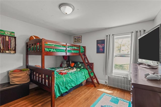 bedroom with radiator and wood finished floors