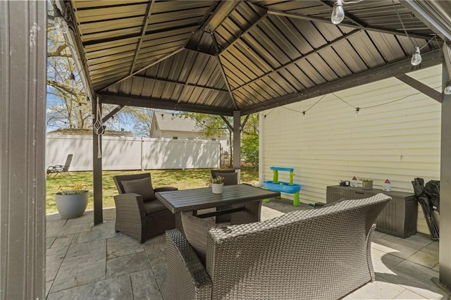 view of patio / terrace with outdoor dining area, fence, and a gazebo