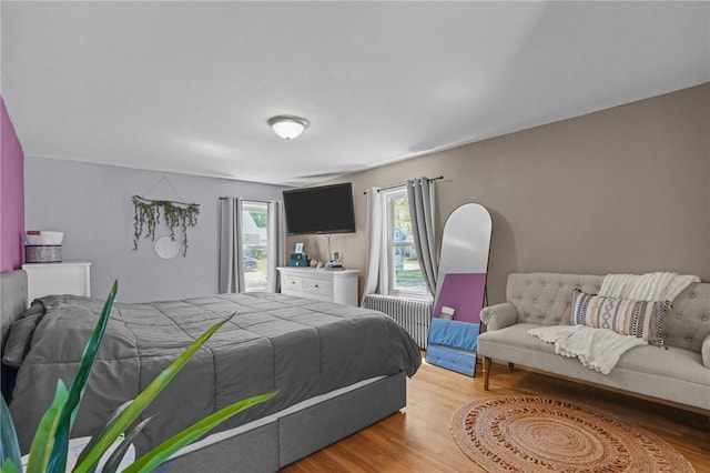 bedroom featuring radiator heating unit and light wood-type flooring