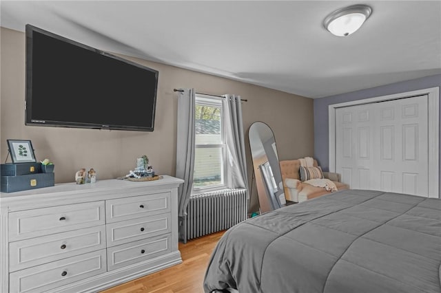 bedroom featuring light wood-style floors and radiator heating unit