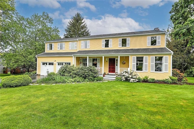 colonial-style house featuring a porch, an attached garage, a front lawn, and a chimney