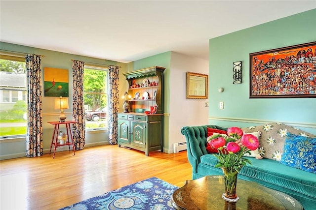 living room with a baseboard radiator, wood finished floors, and baseboards