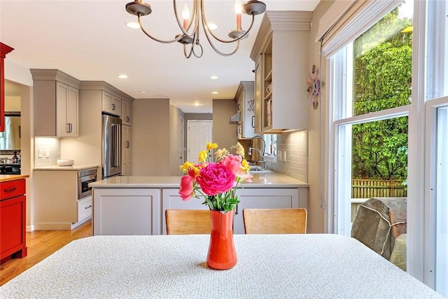 dining area with light wood finished floors, a chandelier, and recessed lighting