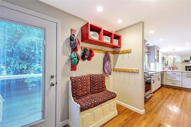mudroom with light wood-style floors, recessed lighting, baseboards, and a sink