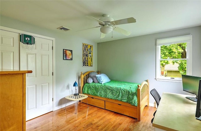 bedroom featuring wood finished floors, baseboards, a ceiling fan, and a desk