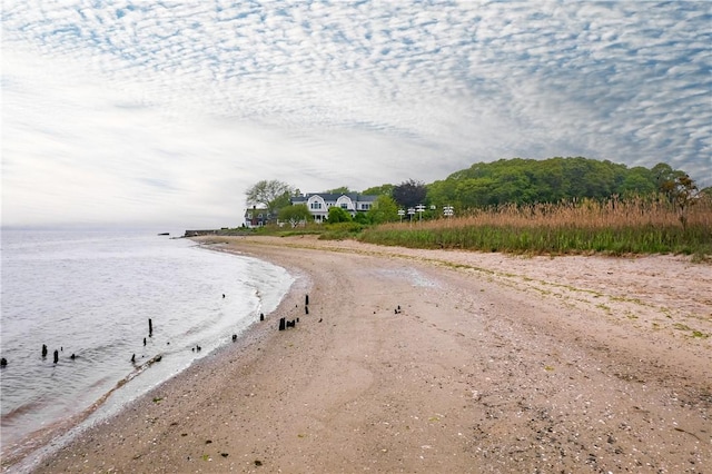 view of dirt / gravel road featuring view of water and beach