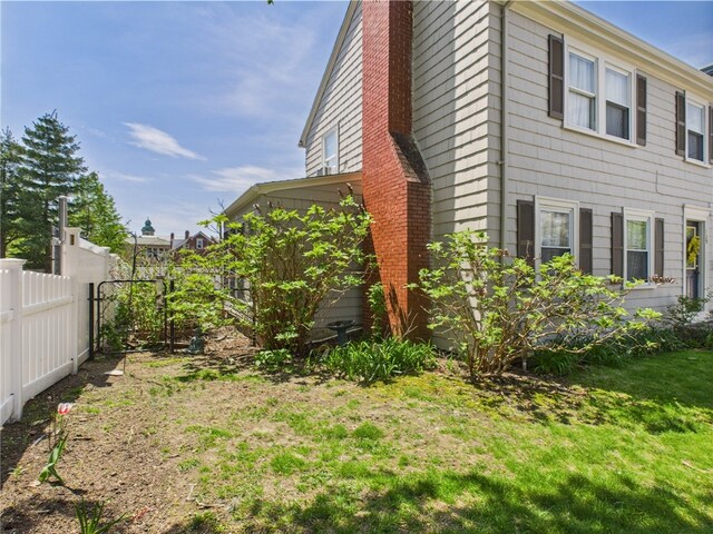 135 Cypress St, Providence, RI 02906 - view of side of property with a yard, a chimney, and fence