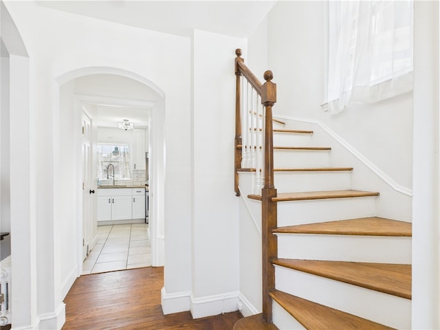 135 Cypress St, Providence, RI 02906 - stairway featuring arched walkways, baseboards, and wood finished floors