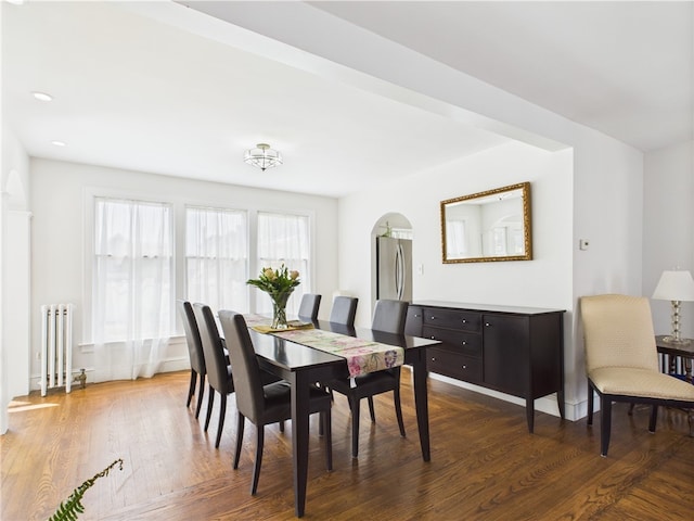 135 Cypress St, Providence, RI 02906 - dining space featuring radiator, arched walkways, and dark wood-style floors