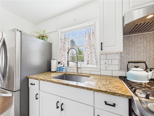 135 Cypress St, Providence, RI 02906 - kitchen featuring a sink, freestanding refrigerator, white cabinets, exhaust hood, and tasteful backsplash