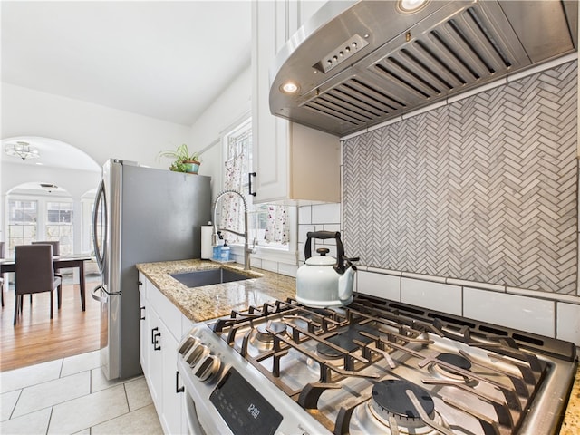 135 Cypress St, Providence, RI 02906 - kitchen featuring premium range hood, a sink, stainless steel appliances, light stone counters, and arched walkways