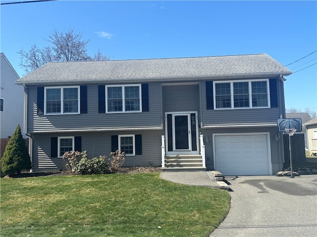 split foyer home with driveway, an attached garage, and a front yard