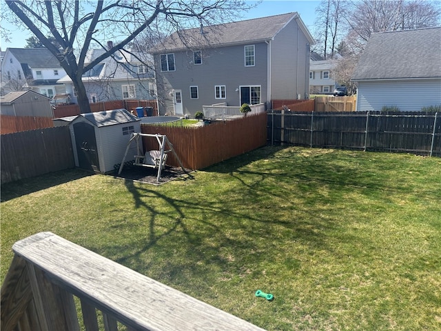 back of house with an outdoor structure, a residential view, a fenced backyard, and a storage unit