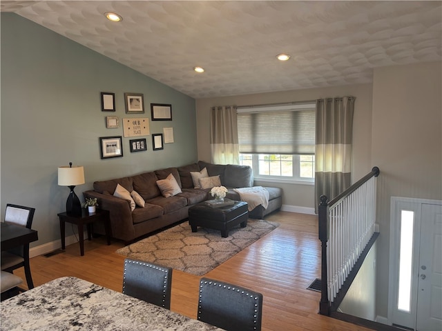 living area with baseboards, wood finished floors, recessed lighting, and vaulted ceiling