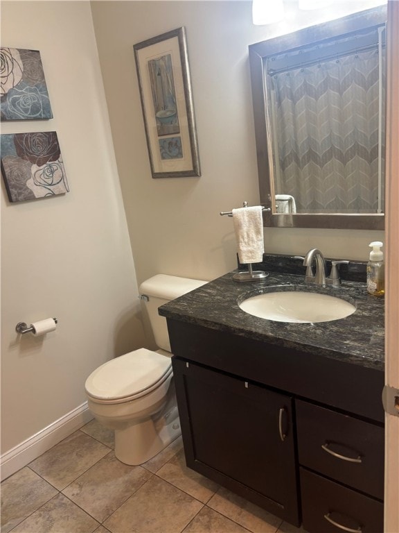 bathroom with tile patterned floors, toilet, baseboards, and vanity