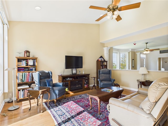 6 Yarmouth Cir S, Kingstown, RI 02879 - living area featuring wood finished floors, a ceiling fan, ornate columns, baseboards, and a towering ceiling