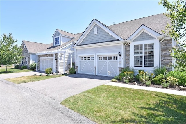 6 Yarmouth Cir S, Kingstown, RI 02879 - view of front of home featuring a front lawn, stone siding, aphalt driveway, and a garage