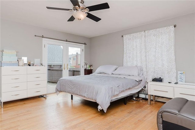 bedroom featuring a baseboard heating unit, light wood-style floors, access to outside, and a ceiling fan