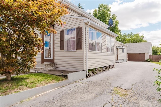 view of side of property featuring entry steps, an outbuilding, and a garage
