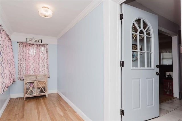 interior space featuring crown molding, light wood-style flooring, and baseboards