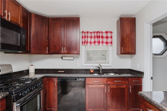 kitchen featuring black appliances, reddish brown cabinets, dark stone counters, and a sink