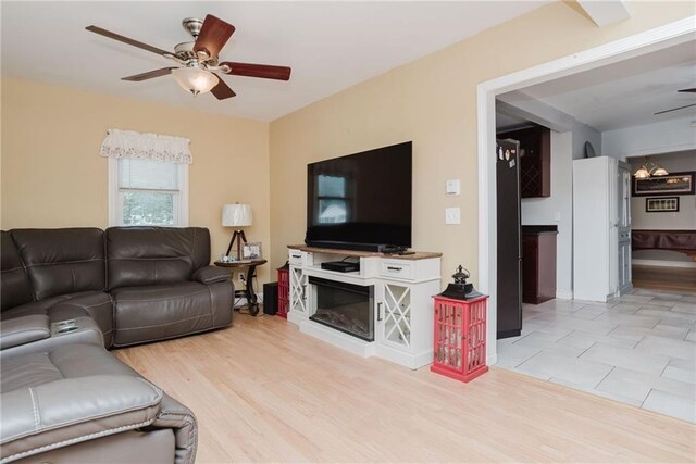 living room with a ceiling fan and light wood-style flooring
