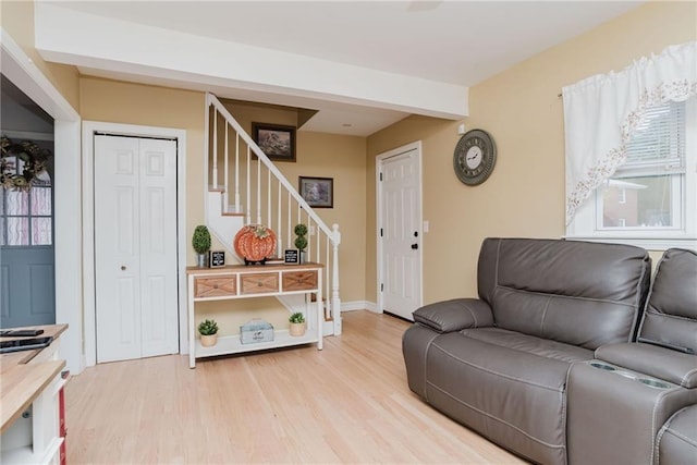 living area with stairs and light wood finished floors