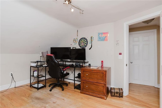 office space with vaulted ceiling, baseboards, and wood finished floors
