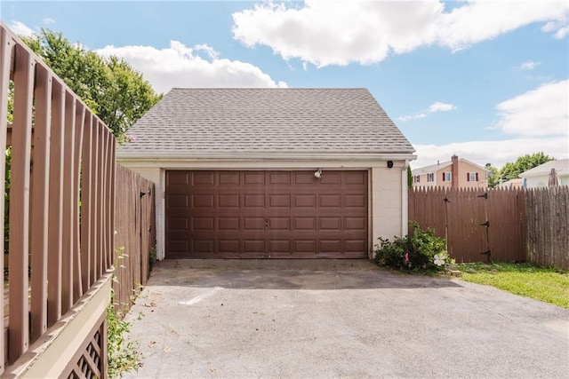 detached garage featuring fence and a gate
