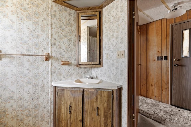 bathroom featuring vanity and wallpapered walls