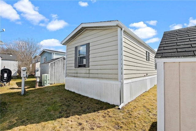 view of property exterior with an outbuilding, a lawn, and a storage unit