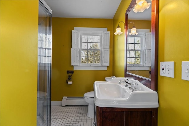 bathroom featuring baseboard heating, toilet, baseboards, tile patterned floors, and vanity