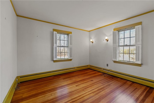 unfurnished room featuring a baseboard radiator, ornamental molding, a wealth of natural light, and hardwood / wood-style floors