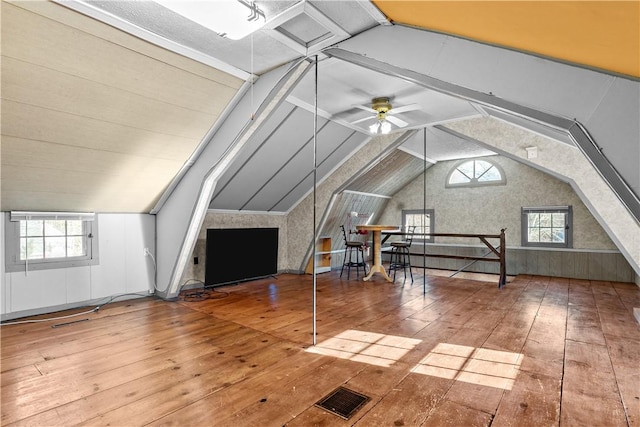 bonus room with lofted ceiling, ceiling fan, visible vents, and wood-type flooring