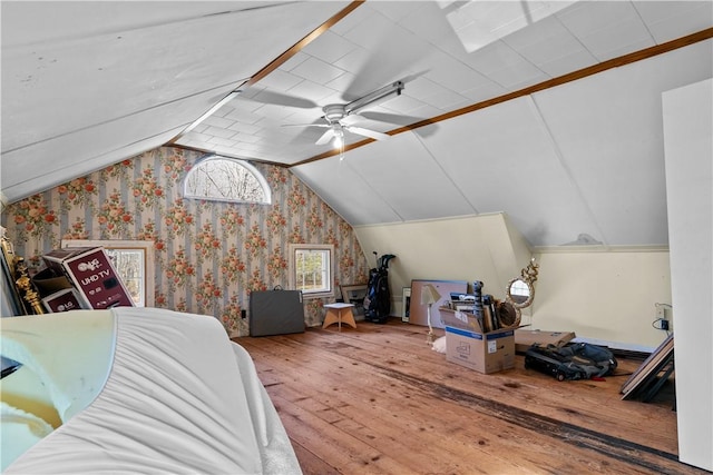 bedroom with wallpapered walls, vaulted ceiling, ceiling fan, and hardwood / wood-style flooring