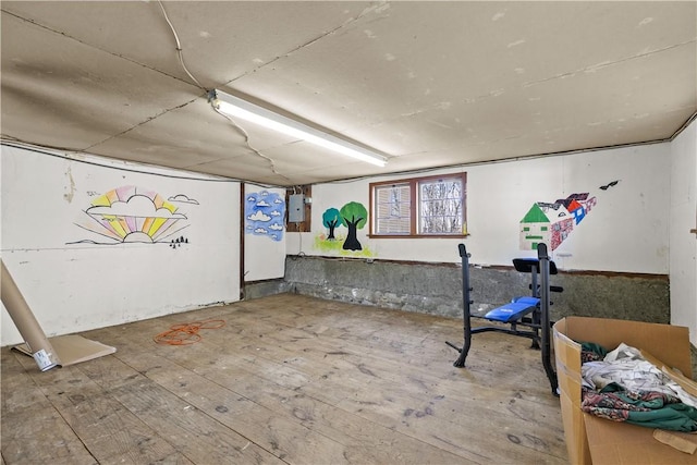 below grade area with electric panel and hardwood / wood-style flooring