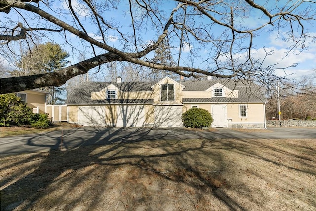 view of property exterior with fence and a shingled roof