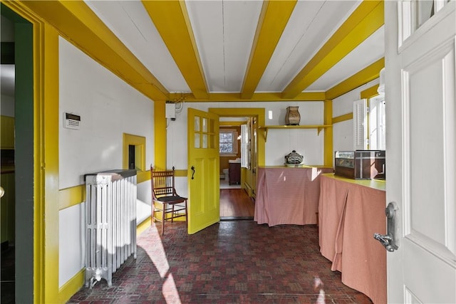 interior space featuring brick floor, baseboards, and a healthy amount of sunlight